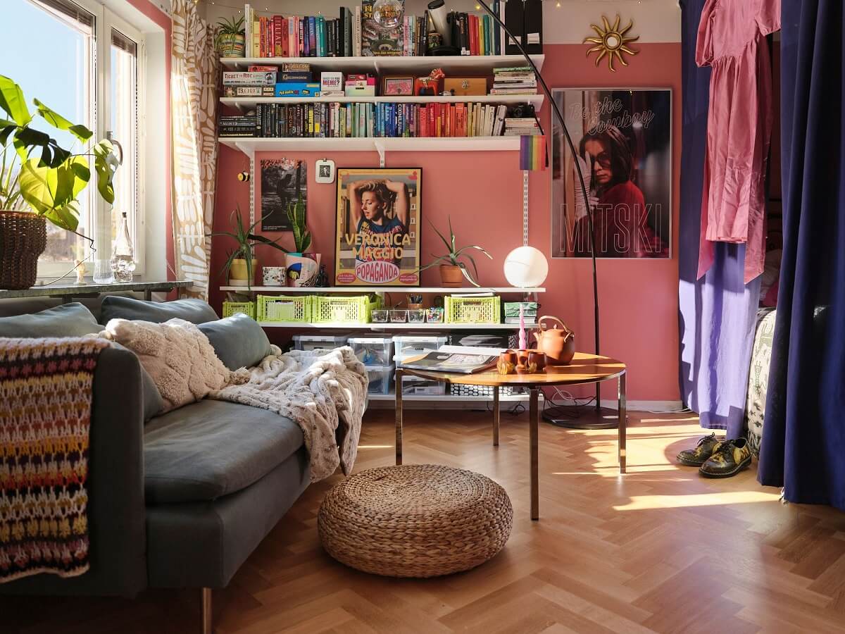 A Bold Pink Studio Apartment with a Light Yellow Kitchen 3 pink studio wth bed niche divided with purple curtains nordroom