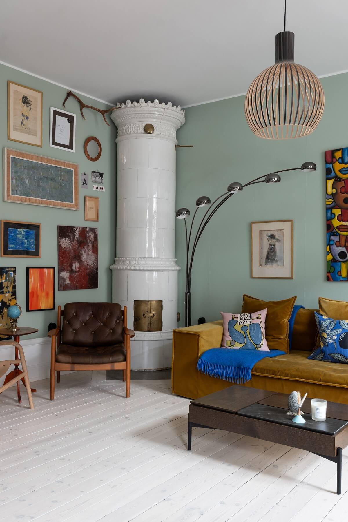scandi living room green walls fireplace art and ochre sofa nordroom