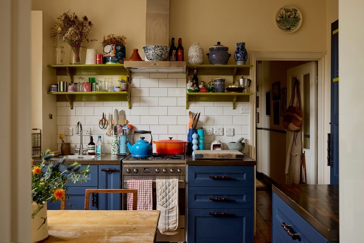 A Beautiful Color Palette in a Victorian London Apartment 5 small cottage kitchen with blue cabinets and green shelves nordroom