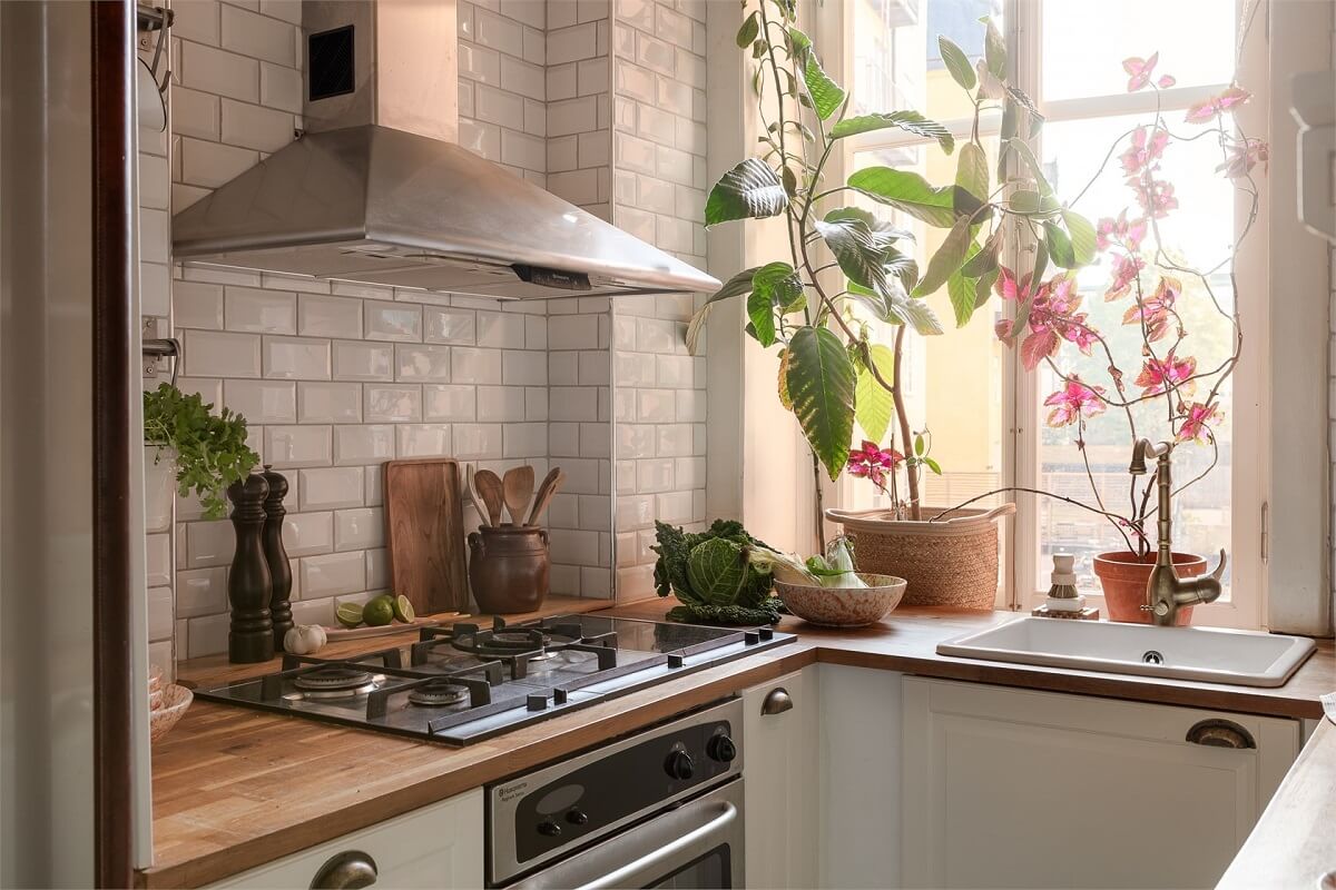 Nature-Inspired Colors in a Charming Stockholm Apartment 11 small ktichen white cabinets and tiles sink under window