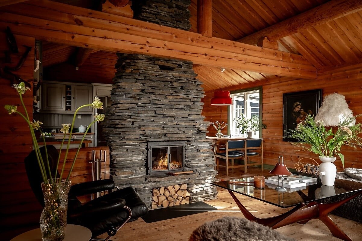 A Warm Scandinavian Log House with a Green Roof 8 stone fireplace in wooden living room