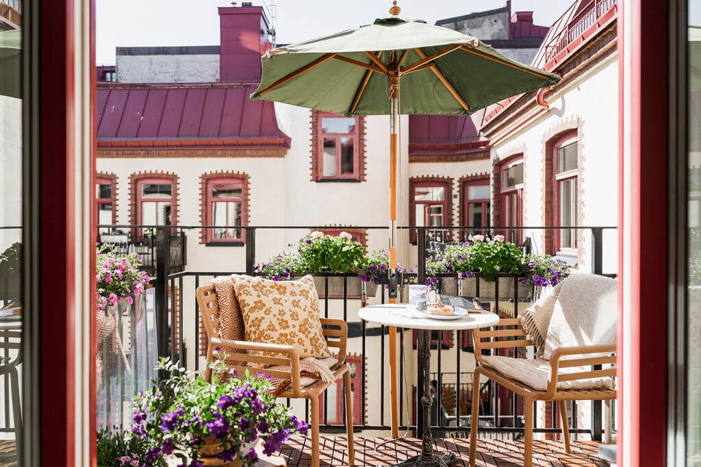 Hannes Mauritzson's Warm Yellow Hygge Apartment in Sweden 33 sunny courtyard balcony with parasol