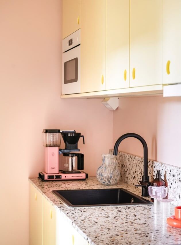 A Small, Colorful Attic Apartment with A Yellow Kitchen 15 yellow kitchen terrazzo worktop black sink