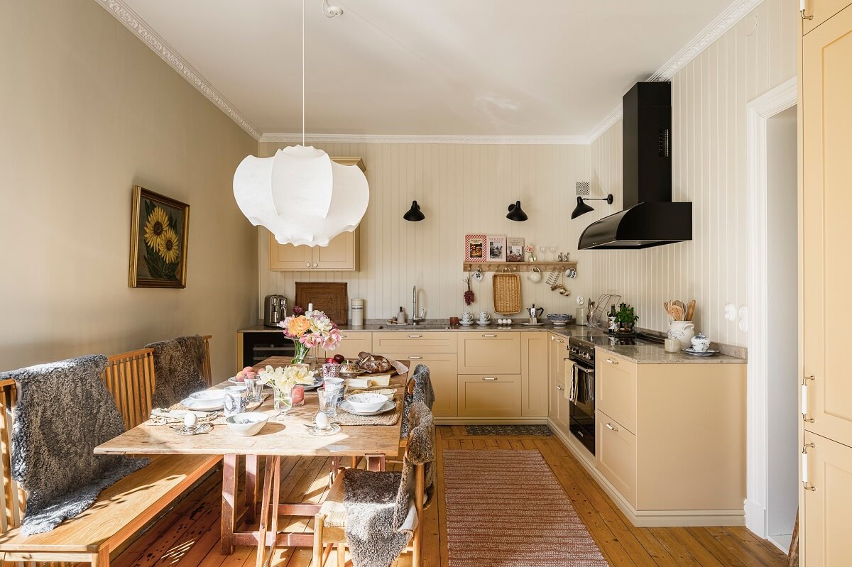 Hannes Mauritzson's Warm Yellow Hygge Apartment in Sweden 17 yellow kitchen with dining table jotun sans wall color