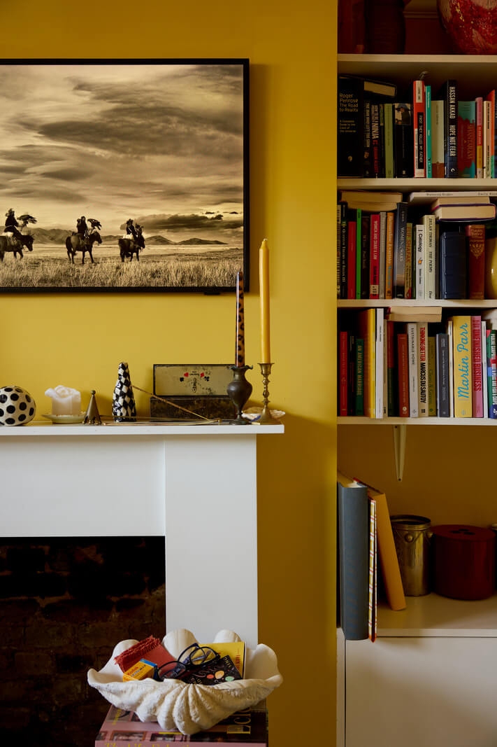 A Beautiful Color Palette in a Victorian London Apartment 3 yellow living room with fireplace flanked by shelves nordroom