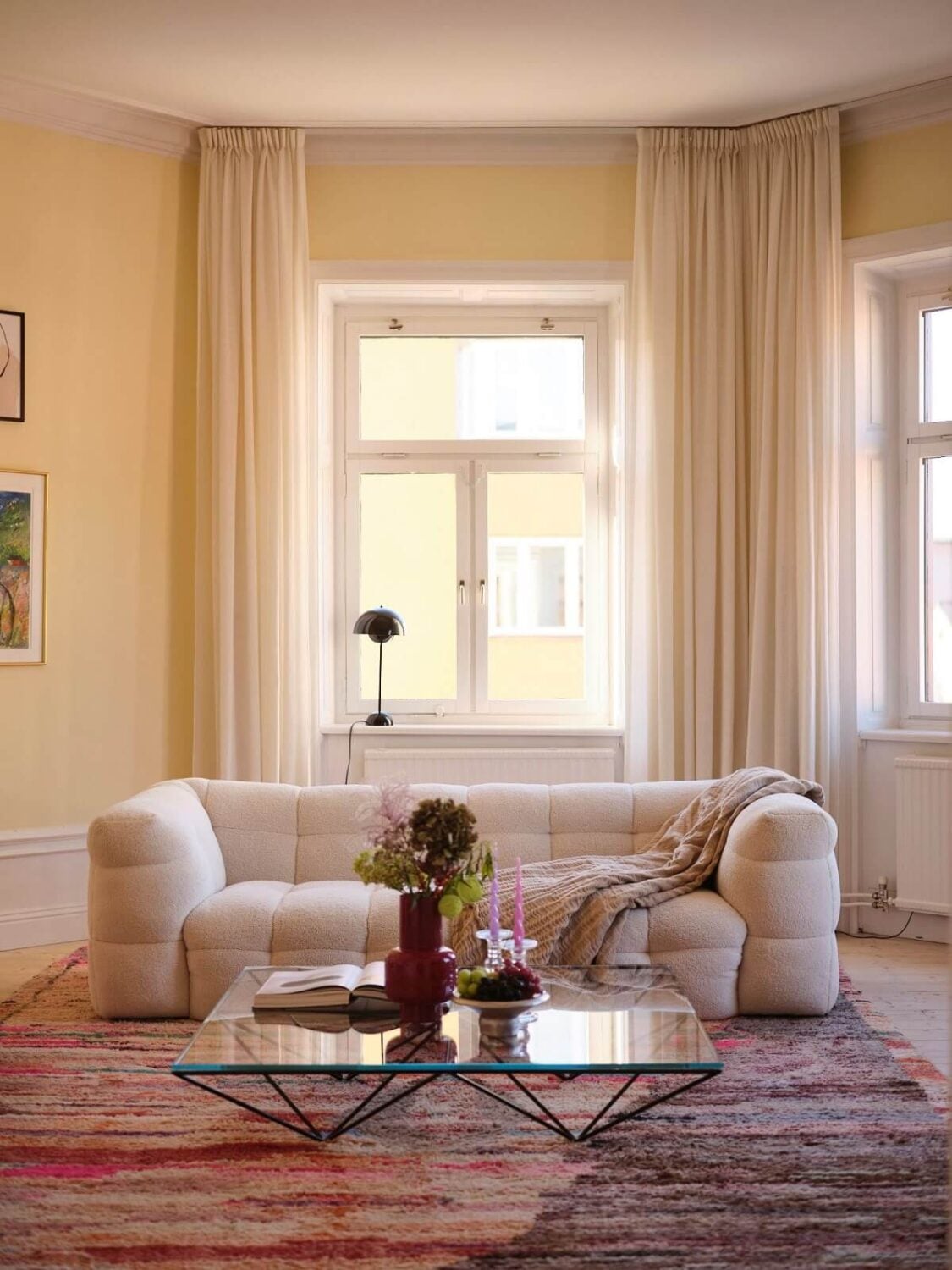 A Light Pastel Yellow and Pink Apartment in Stockholm 6 yellow living room with large colorful rug nordroom