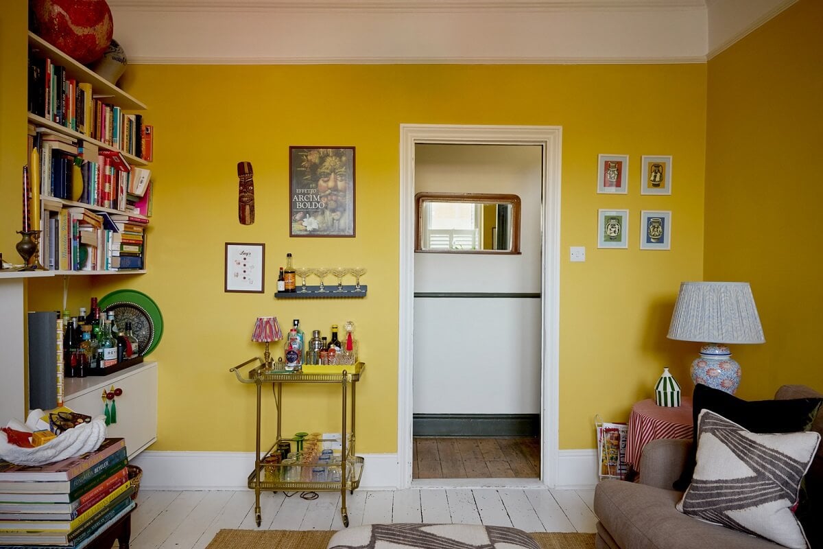 A Beautiful Color Palette in a Victorian London Apartment 4 yellow walls living room bookshelves