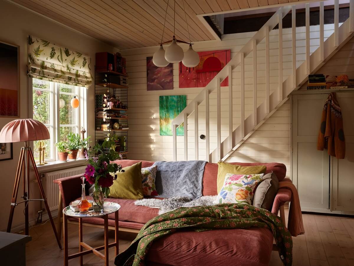 A Charming Swedish Cottage Filled with Art and Color 6 art filled living room pink couch