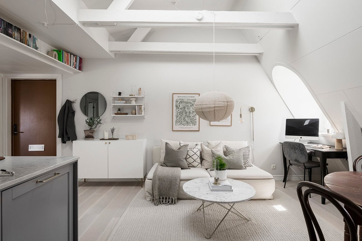 A Swedish Attic Apartment with a Lovely Balcony Overlooking the City 10 attic living room high pitched ceiling wooden beams