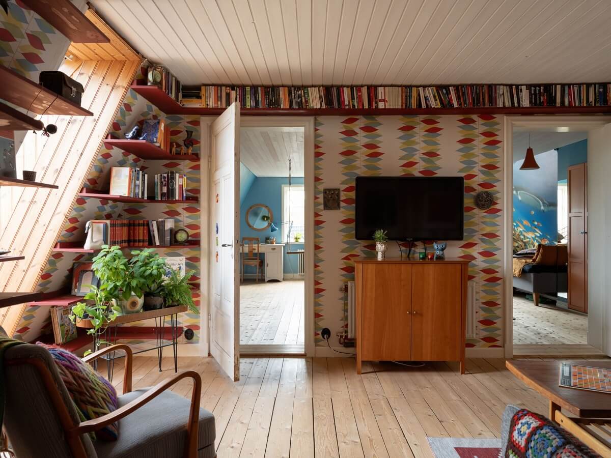 A 1930s Green-Painted Wooden Family Home in Sweden 17 attic sitting room with colorful wallpaper and red bookshelves