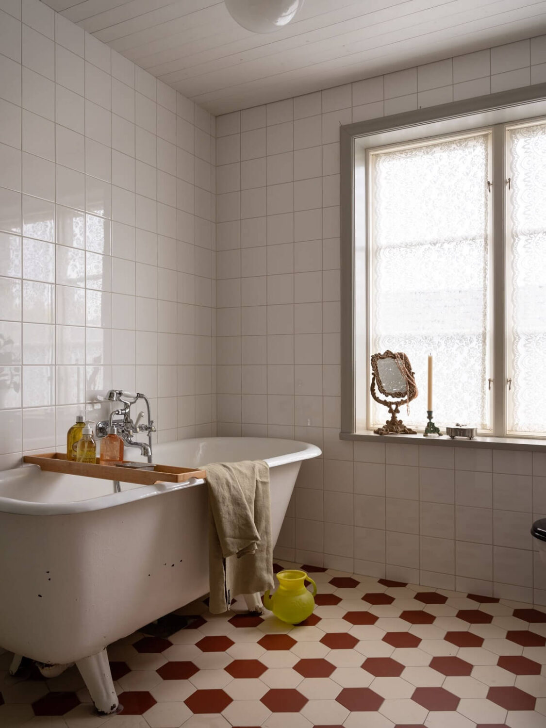 A 1930s Green-Painted Wooden Family Home in Sweden 11 bathroom with red and white floor tiles and freestanding bath