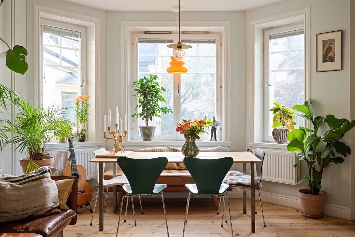 Green Tones in a Turn-of-the-Century Stockholm Apartment 3 bay window with dining table green chairs