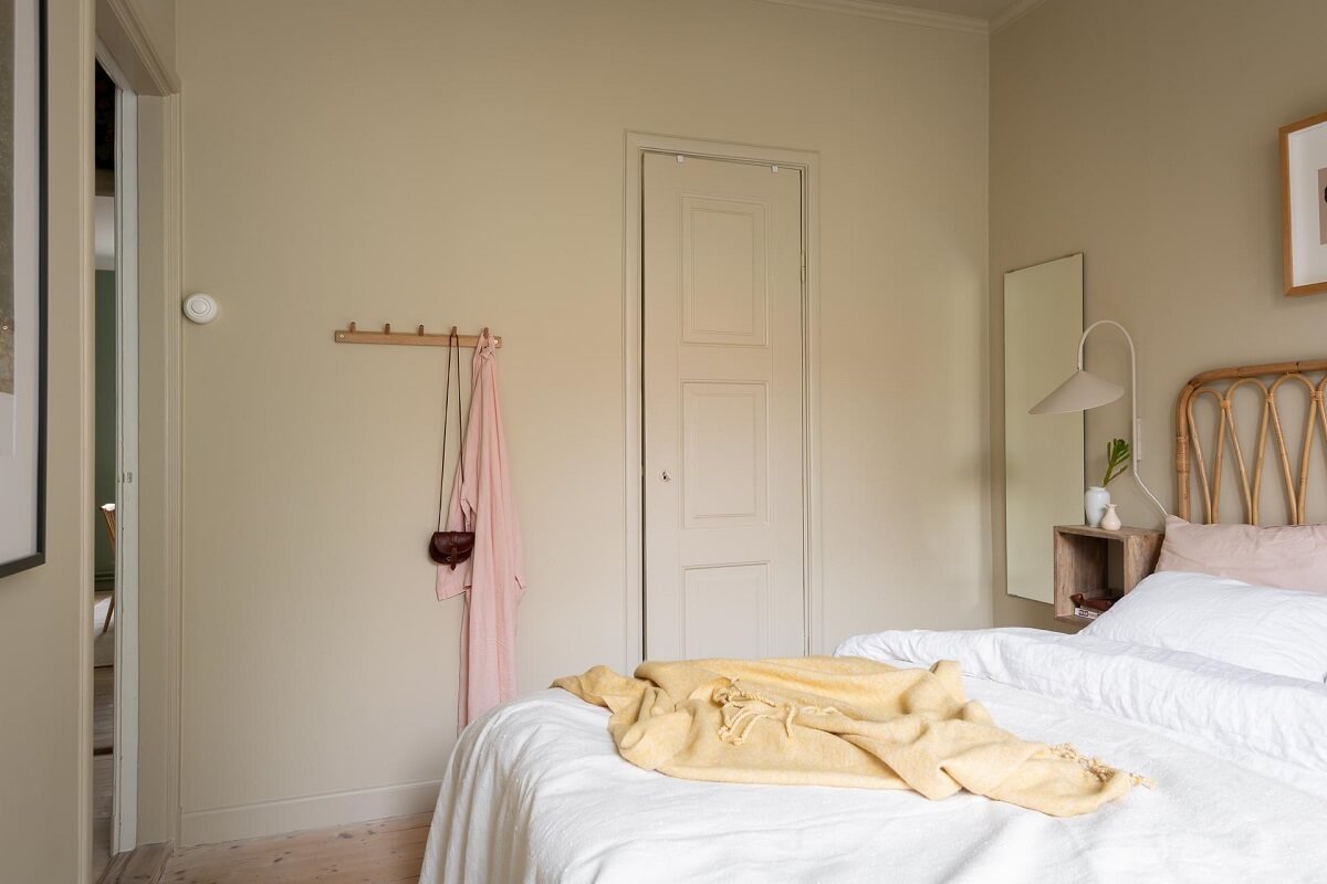 A Swedish Apartment Painted in Calm Beige, Green, and Pink Tones 20 bedroom beige walls rattan bed