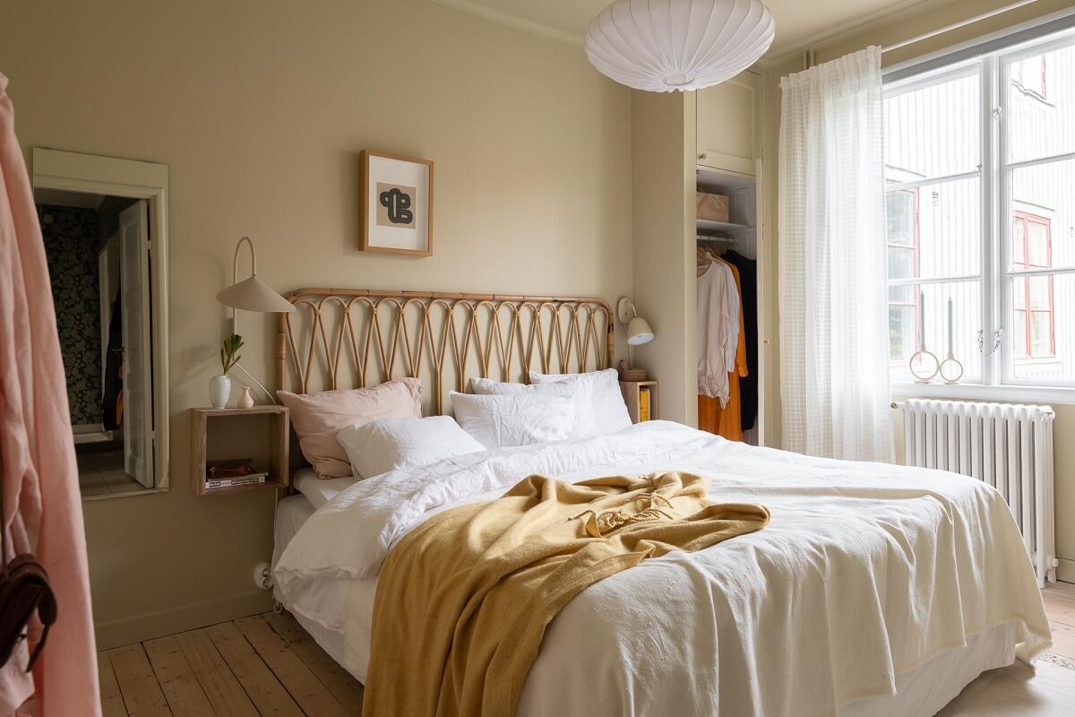 A Swedish Apartment Painted in Calm Beige, Green, and Pink Tones 17 beige bedroom rattan headboard