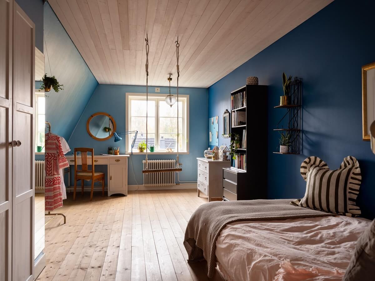 A 1930s Green-Painted Wooden Family Home in Sweden 18 blue bedroom with desk and slanted ceiling