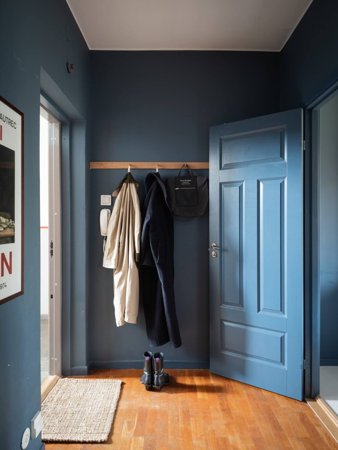 A Small Swedish Apartment with Dark Blue Walls 16 blue hall with simple coat hanger