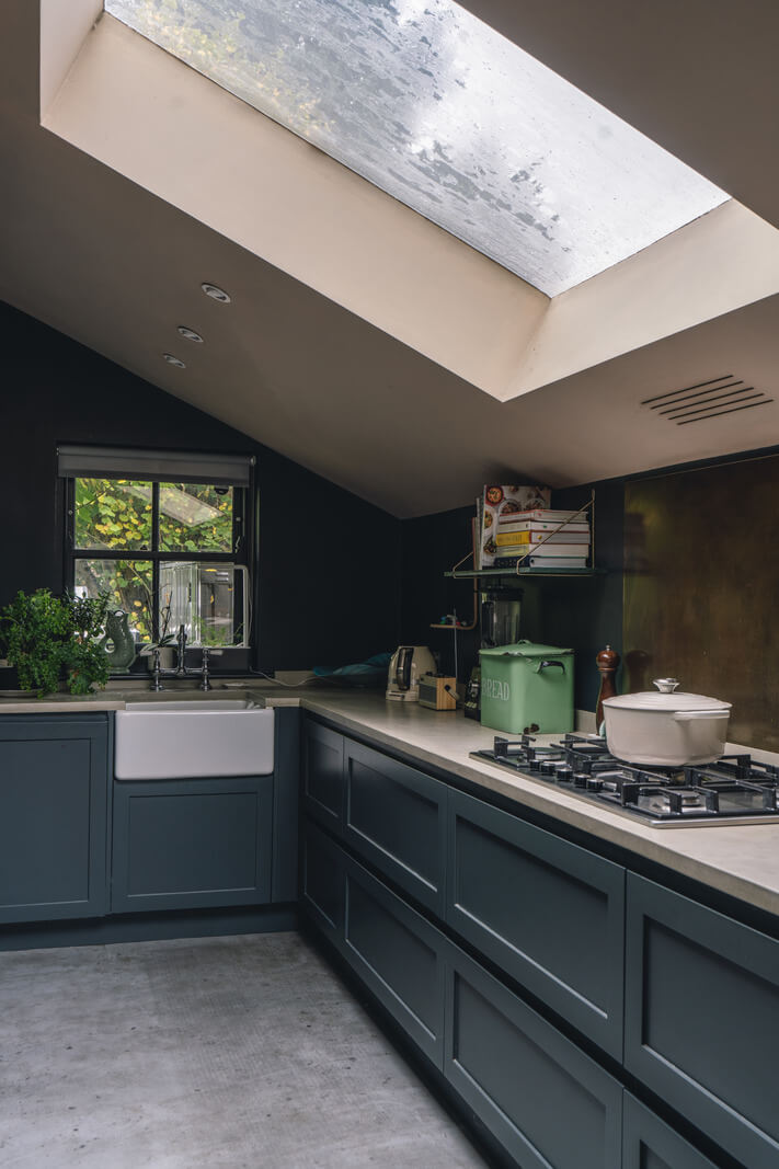 A Grand Ground Floor Apartment with Dark Blue Walls and a Garden 8 blue kitchen cabinets with slanted ceiling and large skylight nordroom