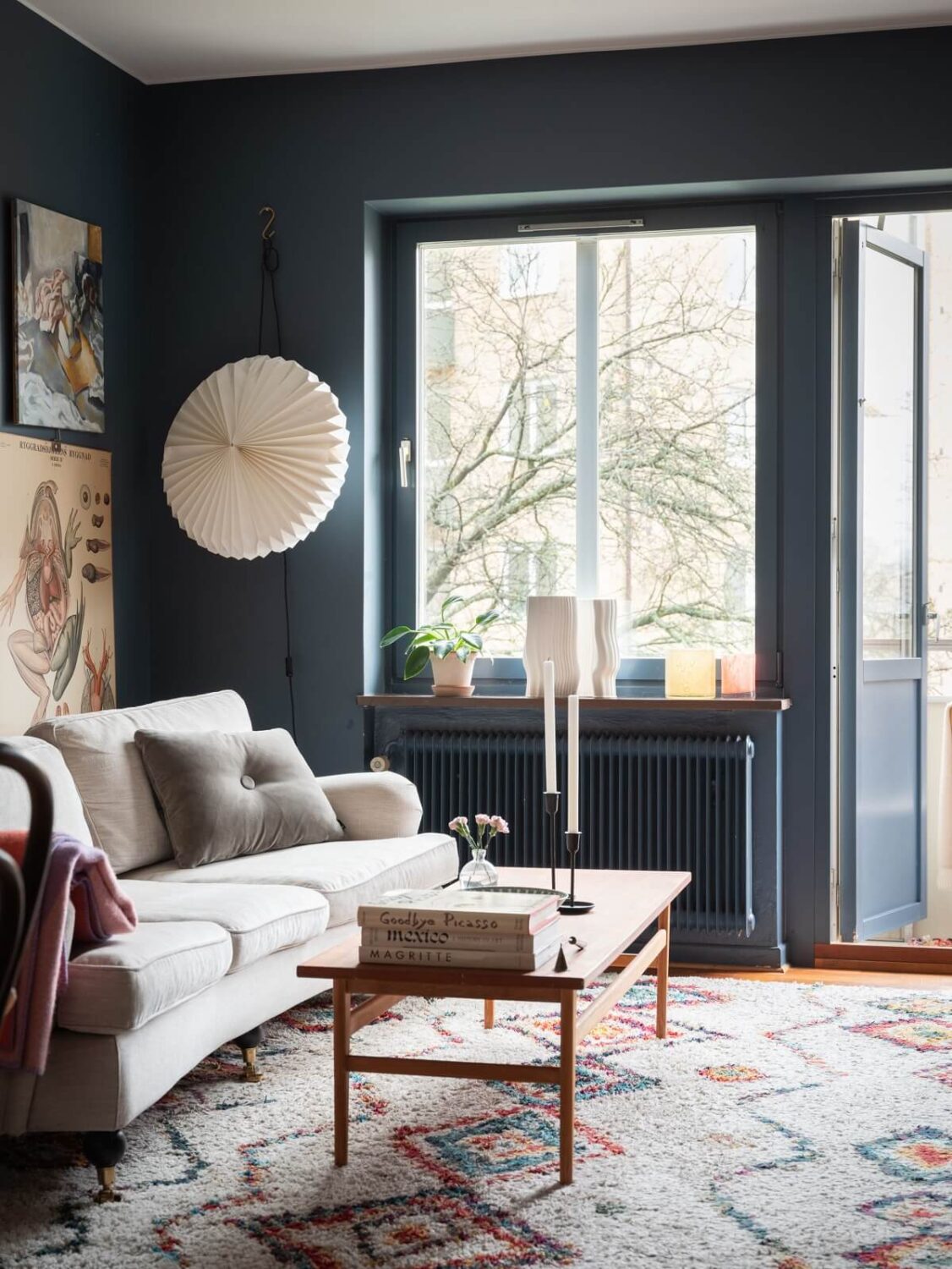 A Small Swedish Apartment with Dark Blue Walls 2 blue living room with colorful rug
