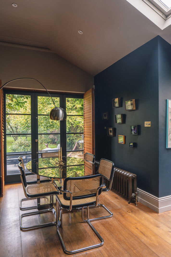 A Grand Ground Floor Apartment with Dark Blue Walls and a Garden 4 blue walls living room with high ceiling and glass dining table nordroom