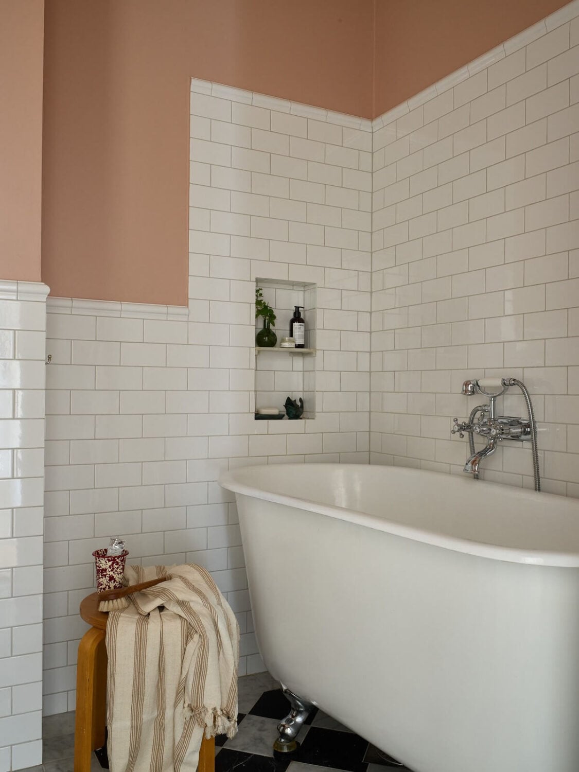 A Colorful Turn-of-the-Century Family Apartment in Stockholm 29 blush pink bathroom walls white tiles bath