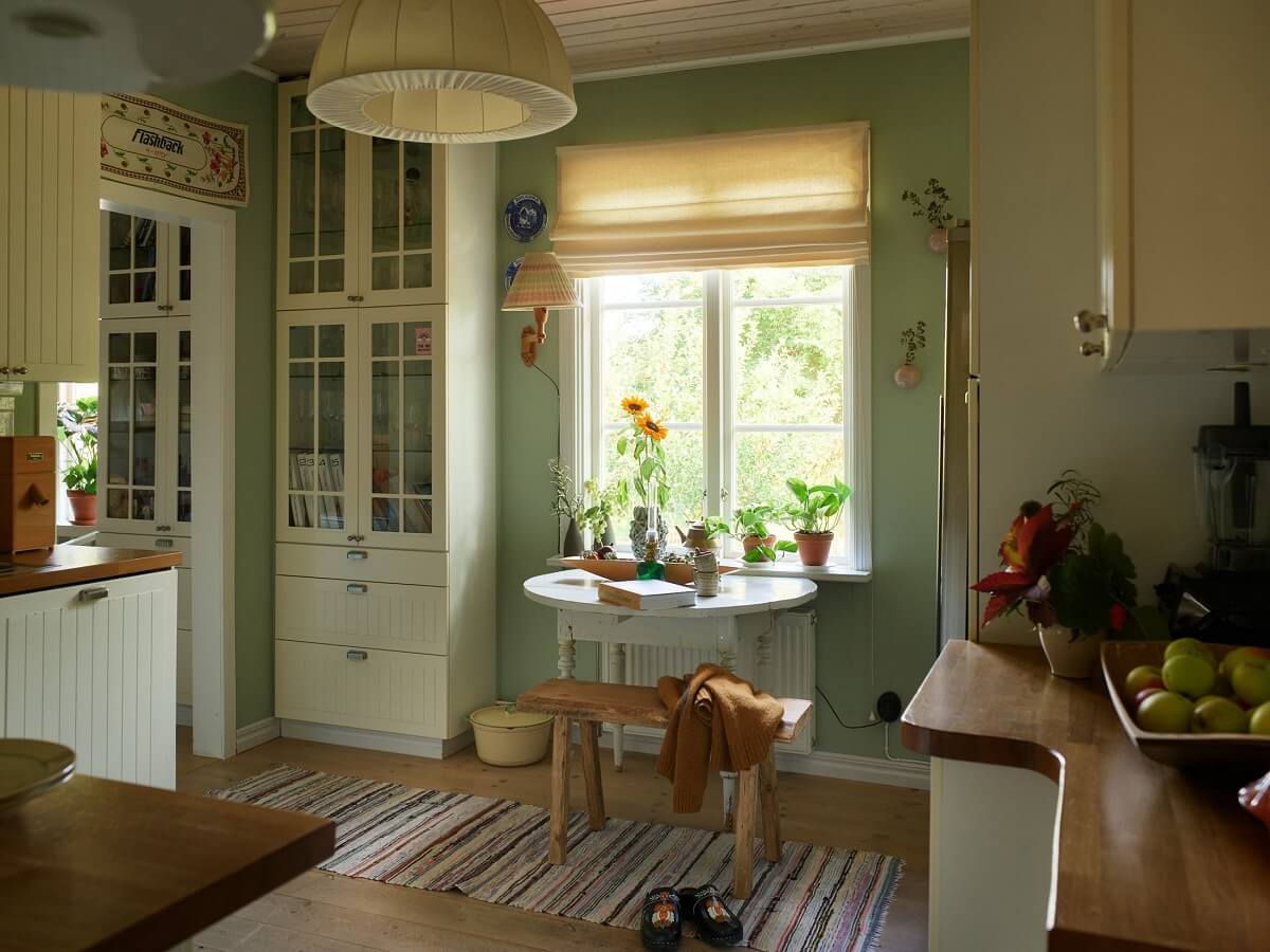 A Charming Swedish Cottage Filled with Art and Color 8 cottage kitchen with green walls