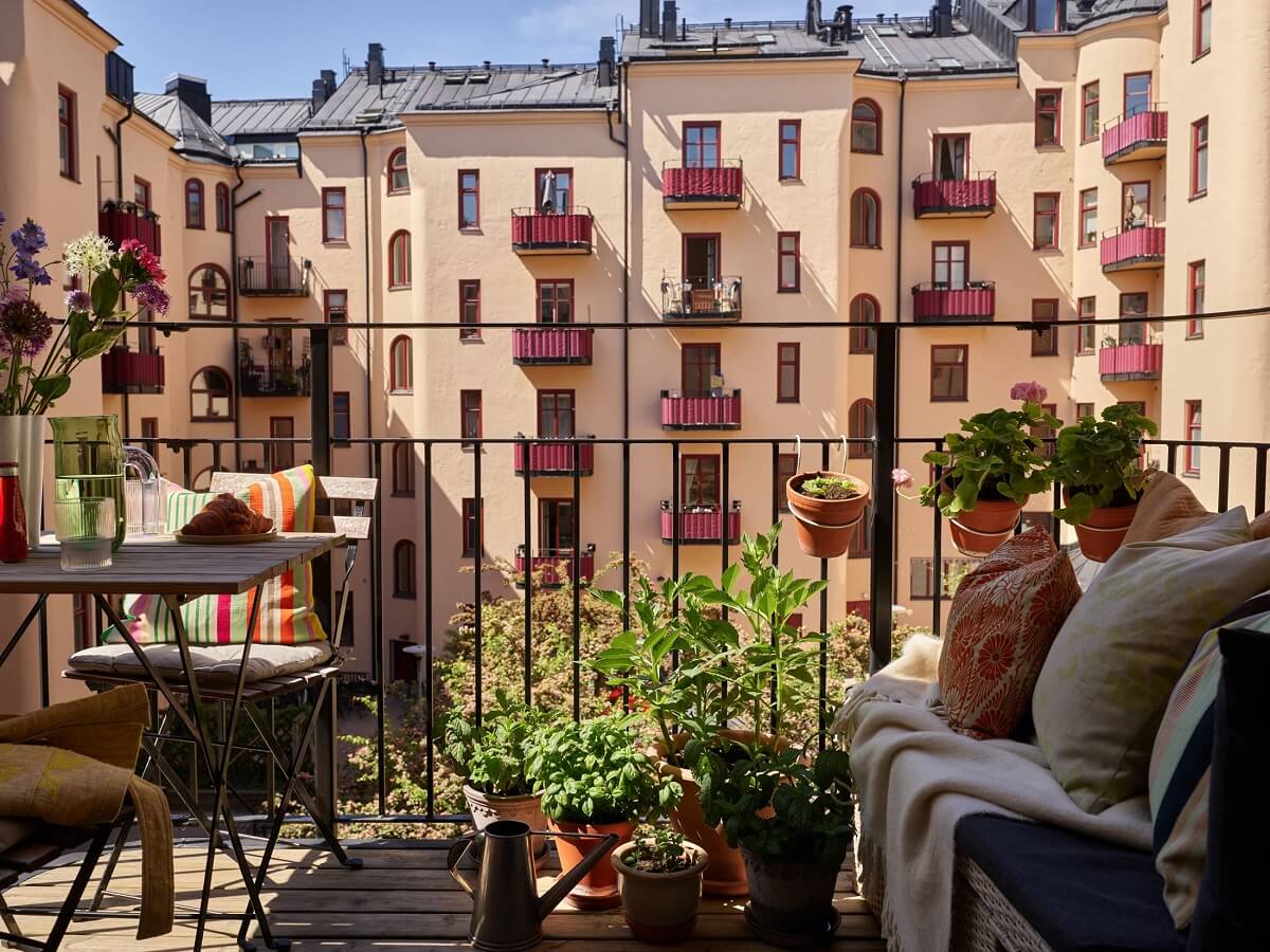 A Light Turn-of-the-Century Apartment with a Cheerful Color Palette 14 coutyard balcony with table and bench