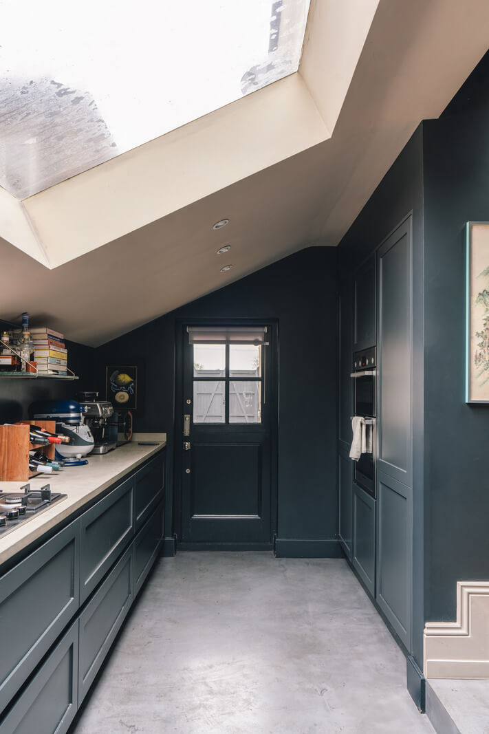 A Grand Ground Floor Apartment with Dark Blue Walls and a Garden 9 dark blue kitchen with slanted ceiling and large skylight nordroom