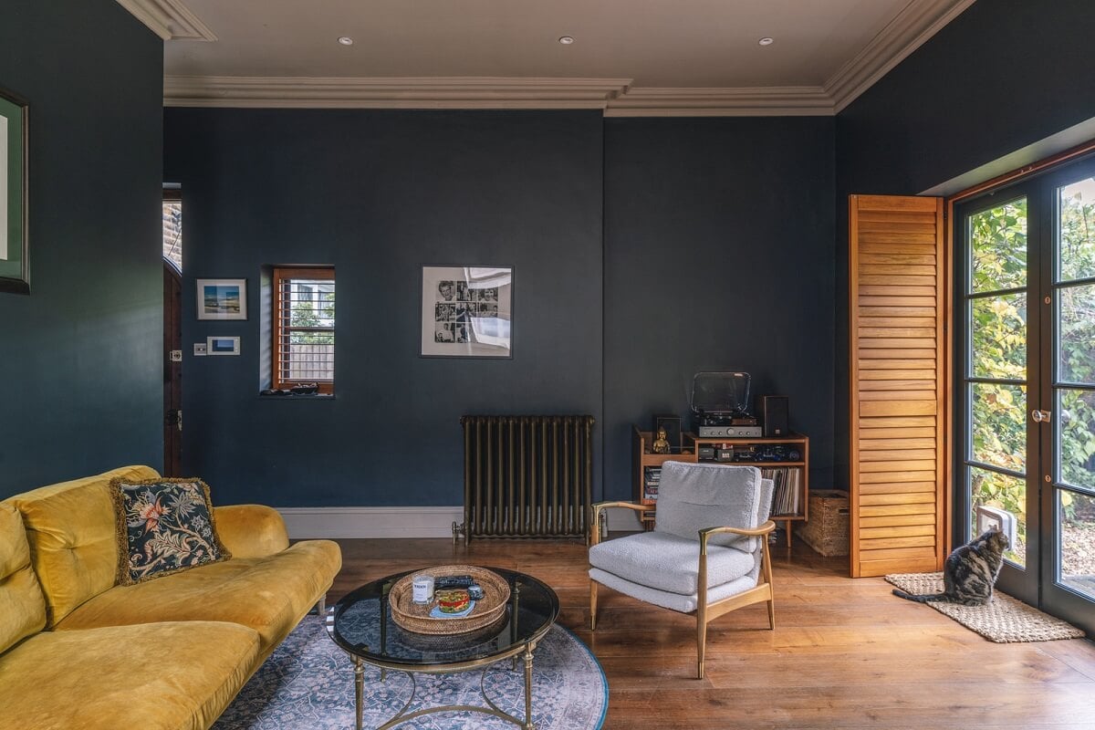 A Grand Ground Floor Apartment with Dark Blue Walls and a Garden 5 dark blue walls living room with yellow couch and brown shutters nordroom