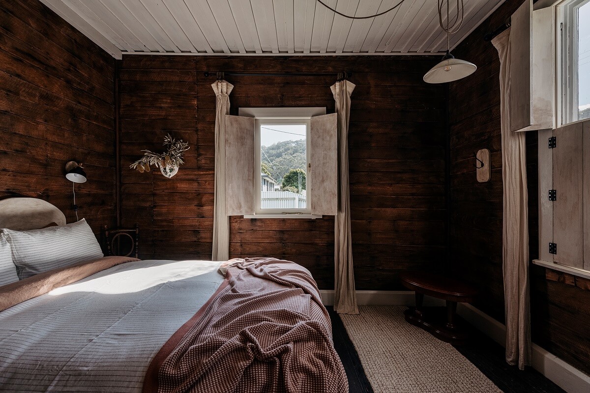 A Cozy Rustic Shipbuilder's Cottage in Northern Tasmania 11 dark wooden walls bedroom