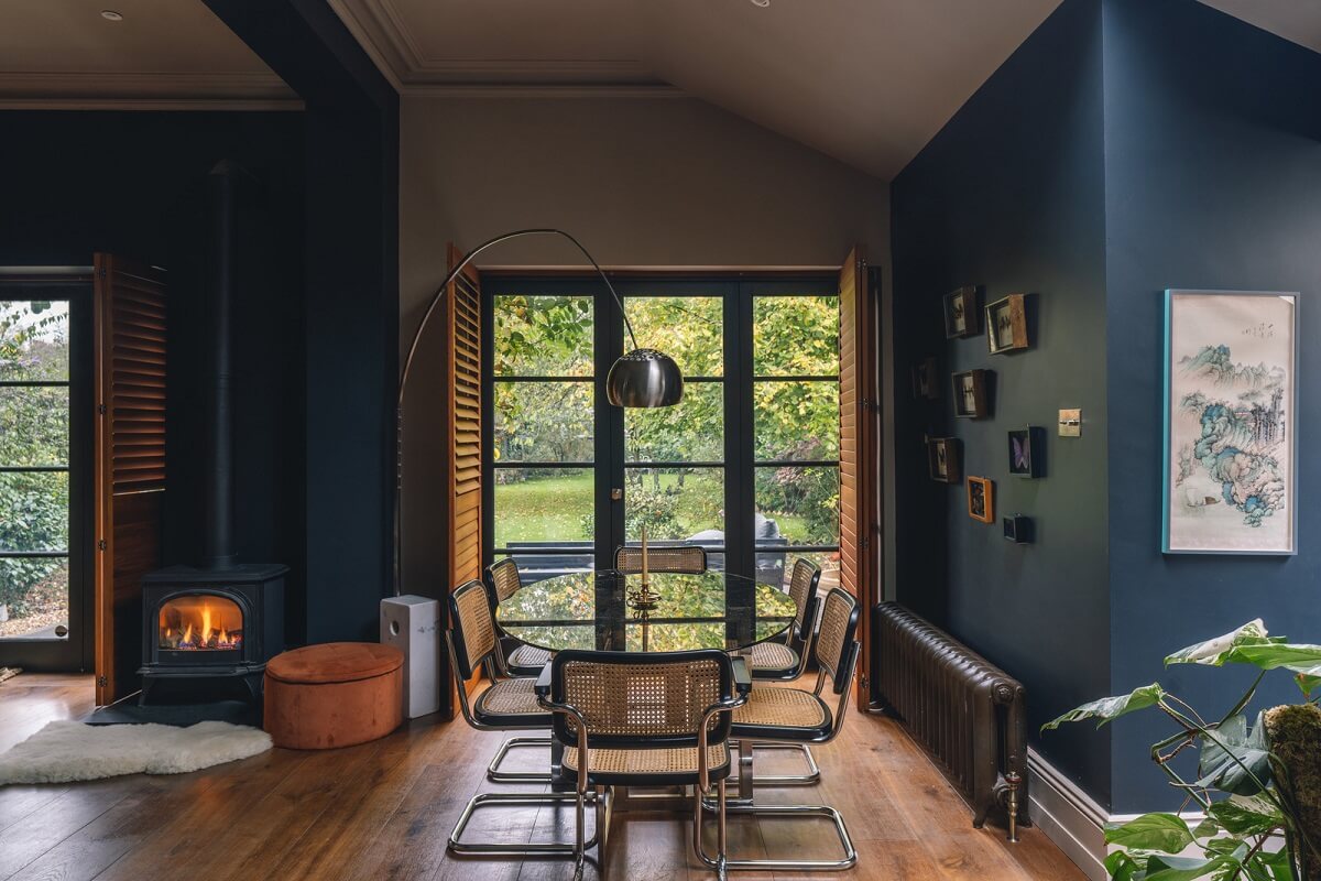 A Grand Ground Floor Apartment with Dark Blue Walls and a Garden 6 dining area in dark blue living room with garden doors and glass table nordroom
