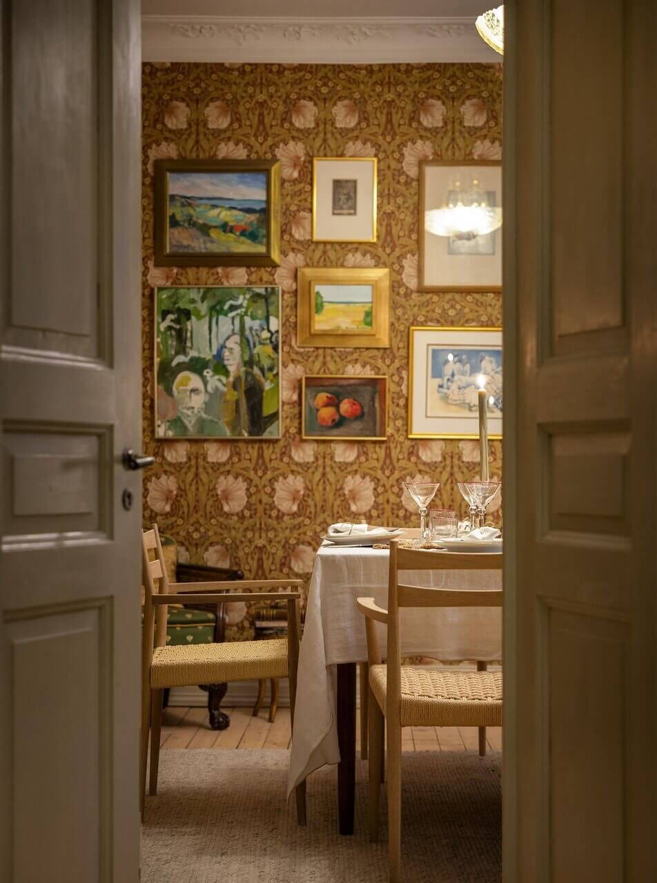 A Stately Apartment with Period Details and Wallpapers 5 dining room at night with william morris wallpaper and art