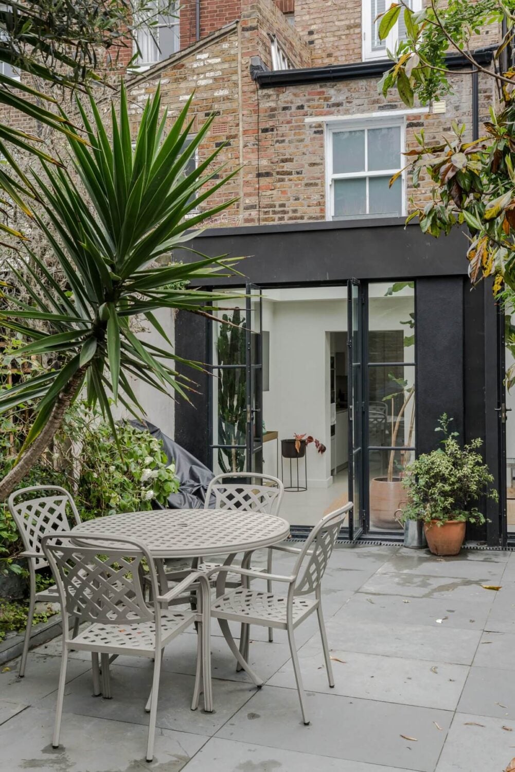 A Bright Extended and Renovated Victorian House in London 20 garden seating and black extension
