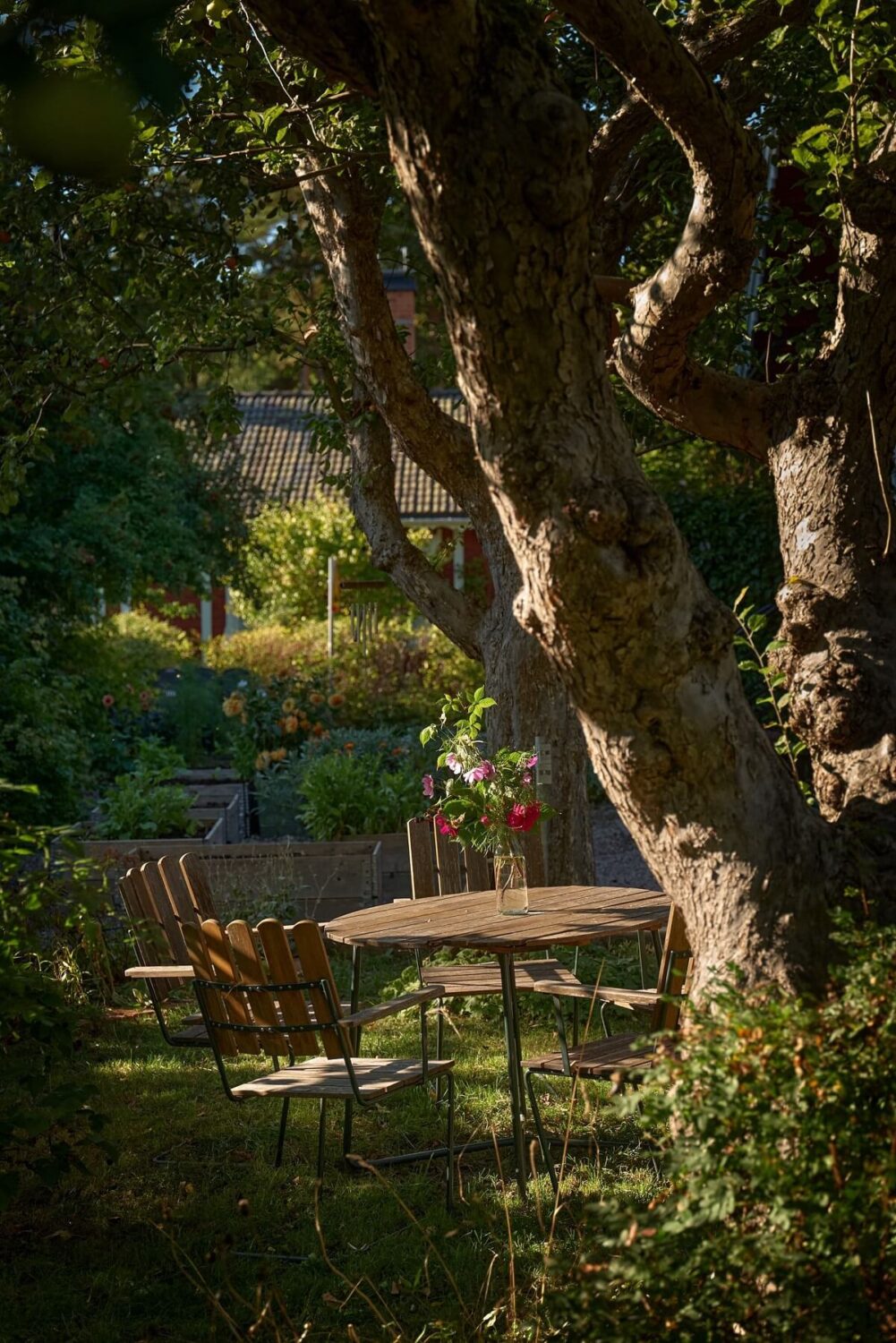 A Charming Swedish Cottage Filled with Art and Color 21 garden seating under tree