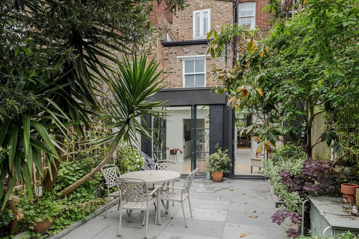 A Bright Extended and Renovated Victorian House in London 19 garden surrounded by mature plants