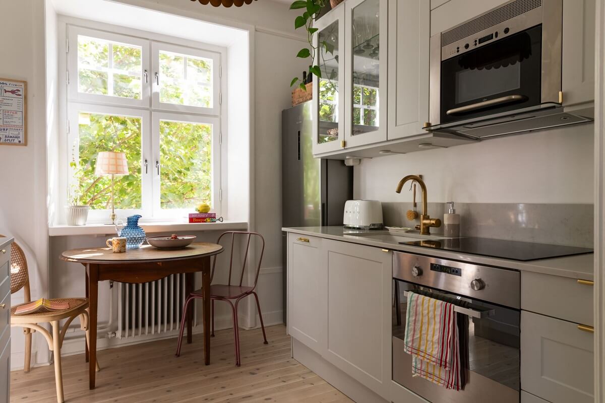 Soft Colors in a Charming Corner Apartment in Stockholm 16 gray kitchen and a small round table