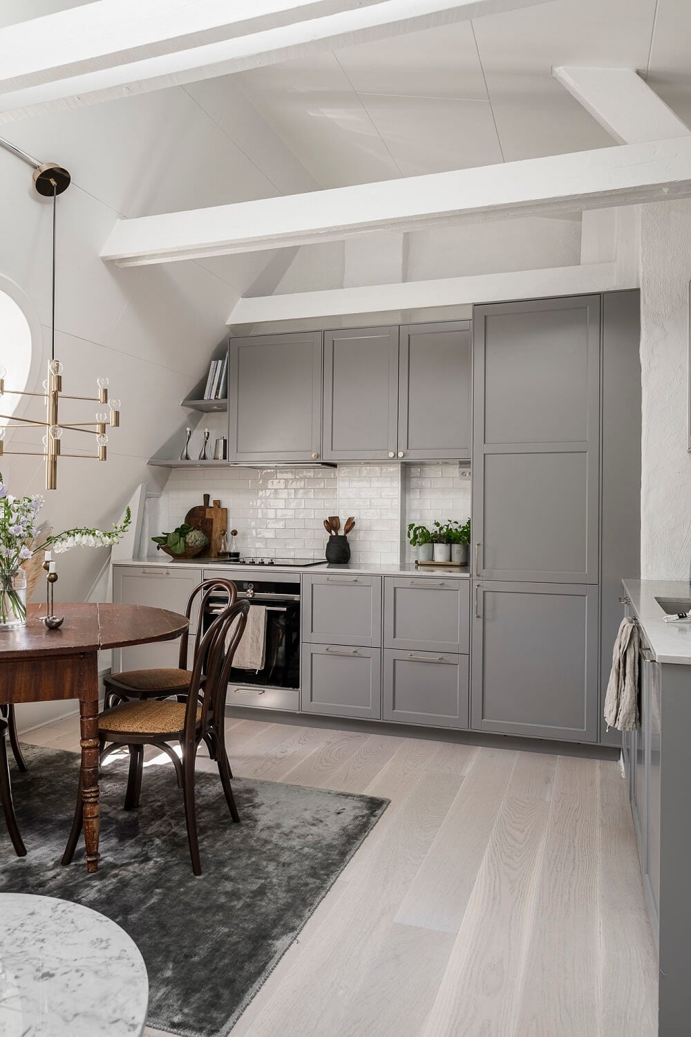A Swedish Attic Apartment with a Lovely Balcony Overlooking the City 4 gray kitchen attic apartment wooden table