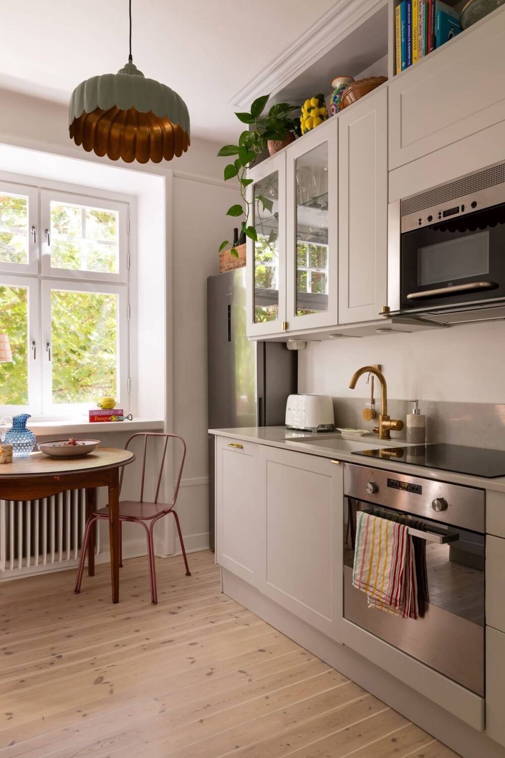 Soft Colors in a Charming Corner Apartment in Stockholm 14 gray kitchen with storage space aboce upper cabinets