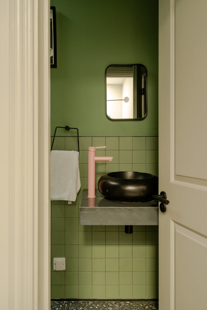 A Colorful Edwardian Family Home in London 22 green bathroom with black sink and pink tap