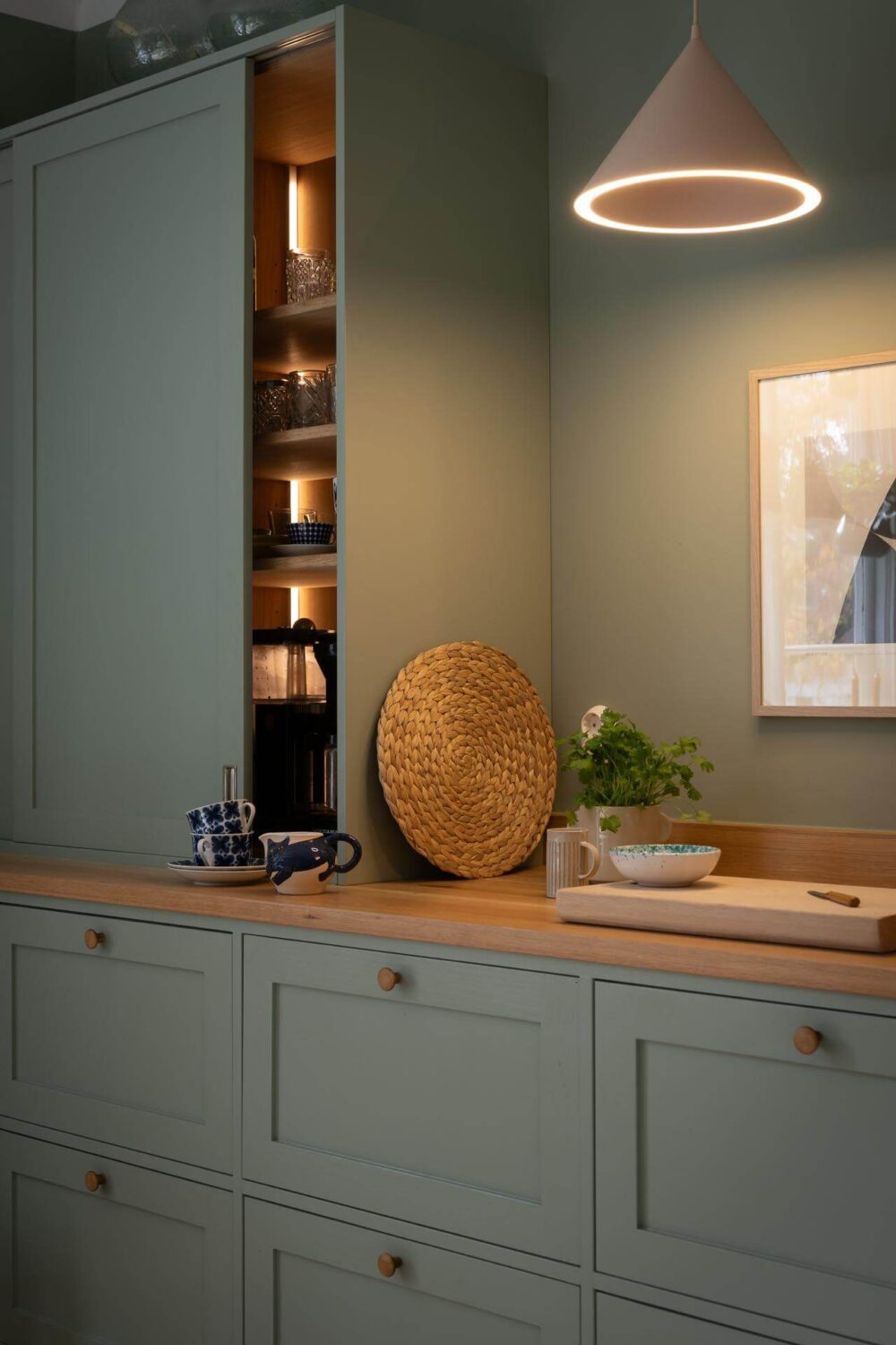 A Swedish Apartment Painted in Calm Beige, Green, and Pink Tones 9 green kitchen cupboards
