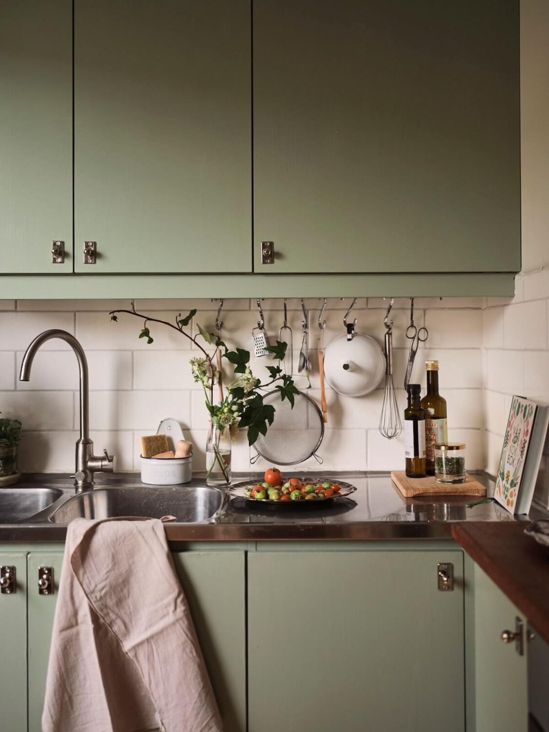 A Small Swedish Apartment with a Social and Semi-Open Floorplan 15 green kitchen detail