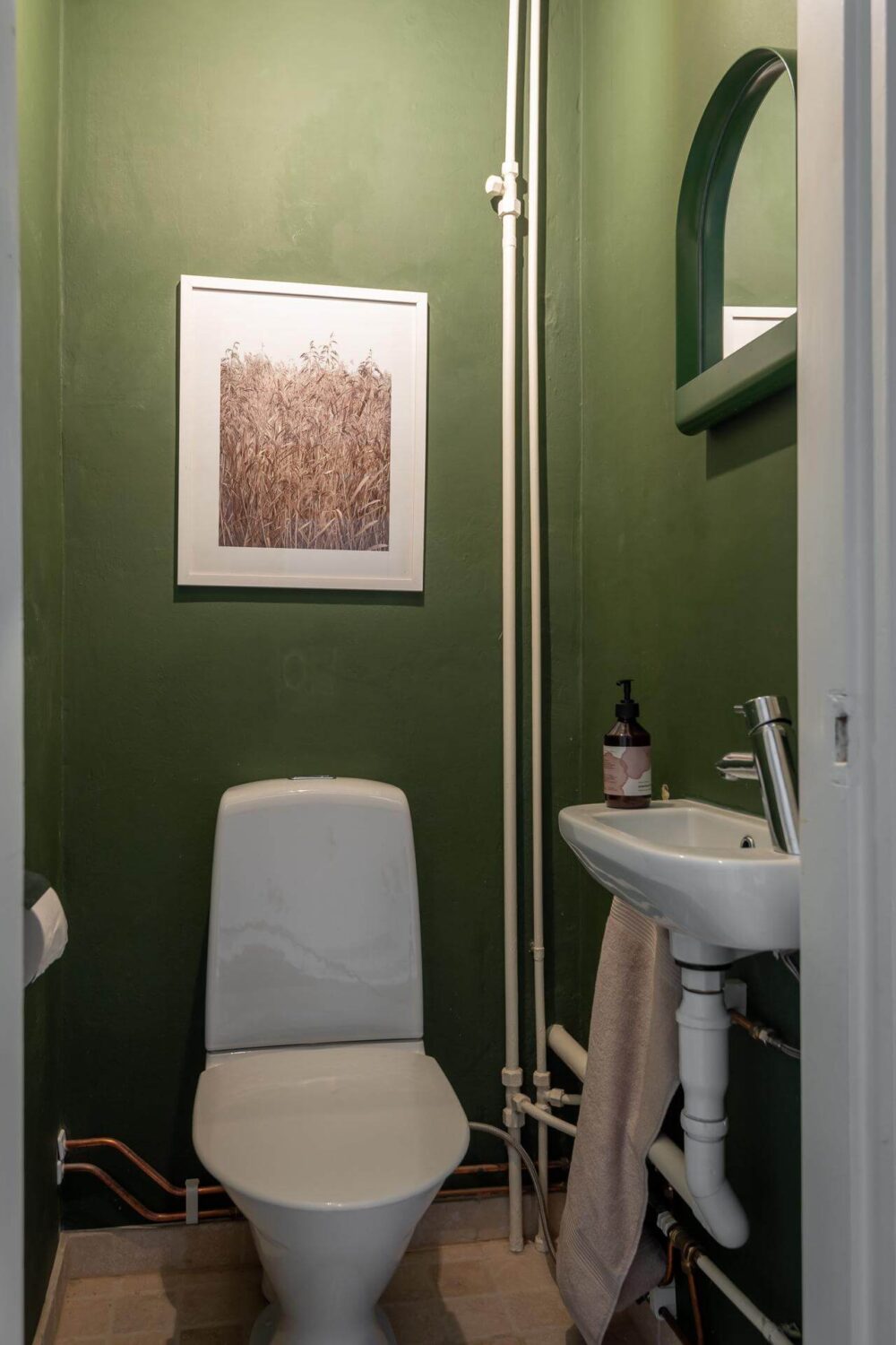 A Swedish Apartment Painted in Calm Beige, Green, and Pink Tones 26 green powder room