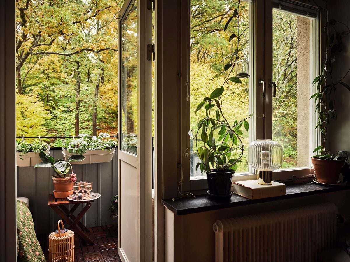 A Small Swedish Apartment with a Social and Semi-Open Floorplan 5 green view living room and balcony
