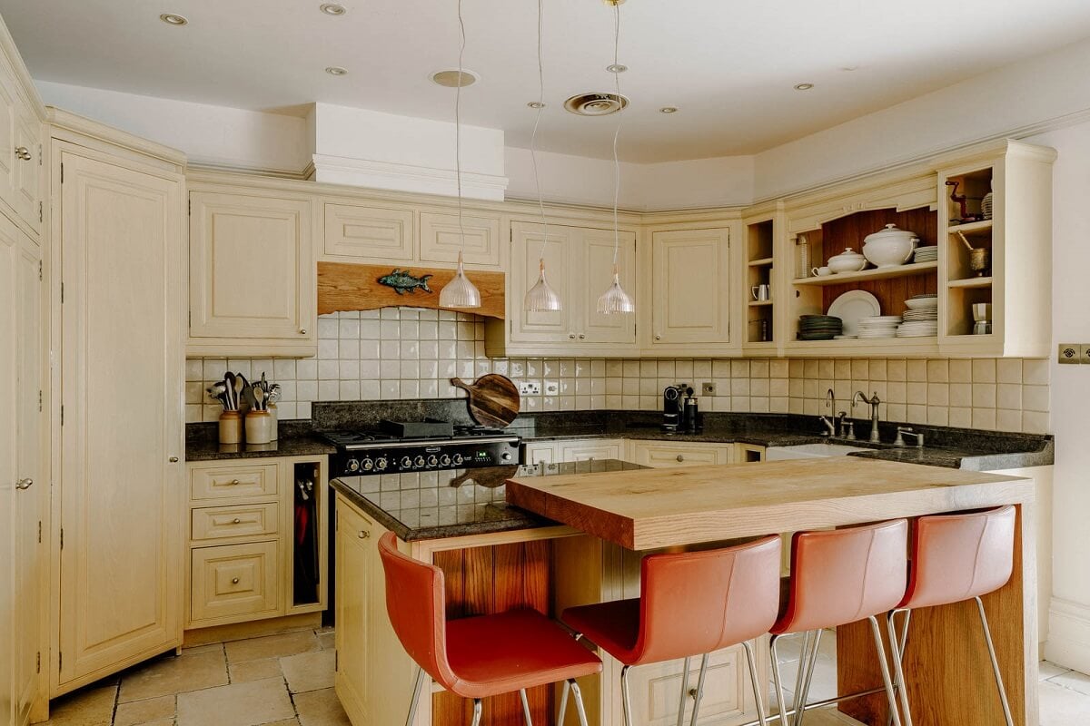 A Grand Arts and Crafts House in London 5 kitchen beige cabinets island bar seating