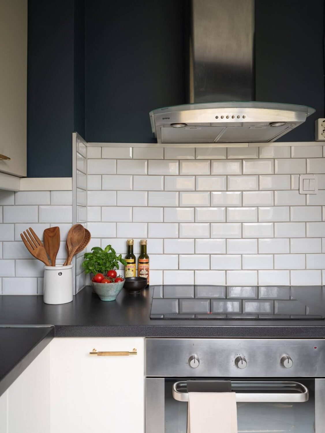 A Small Swedish Apartment with Dark Blue Walls 9 kitchen blue wall white tiles