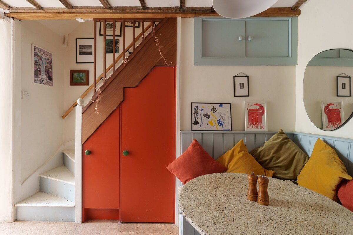 The 2026 Home Decor and Color Trends, According to Pinterest 32 kitchen built in seating and orange cupboards under stairs