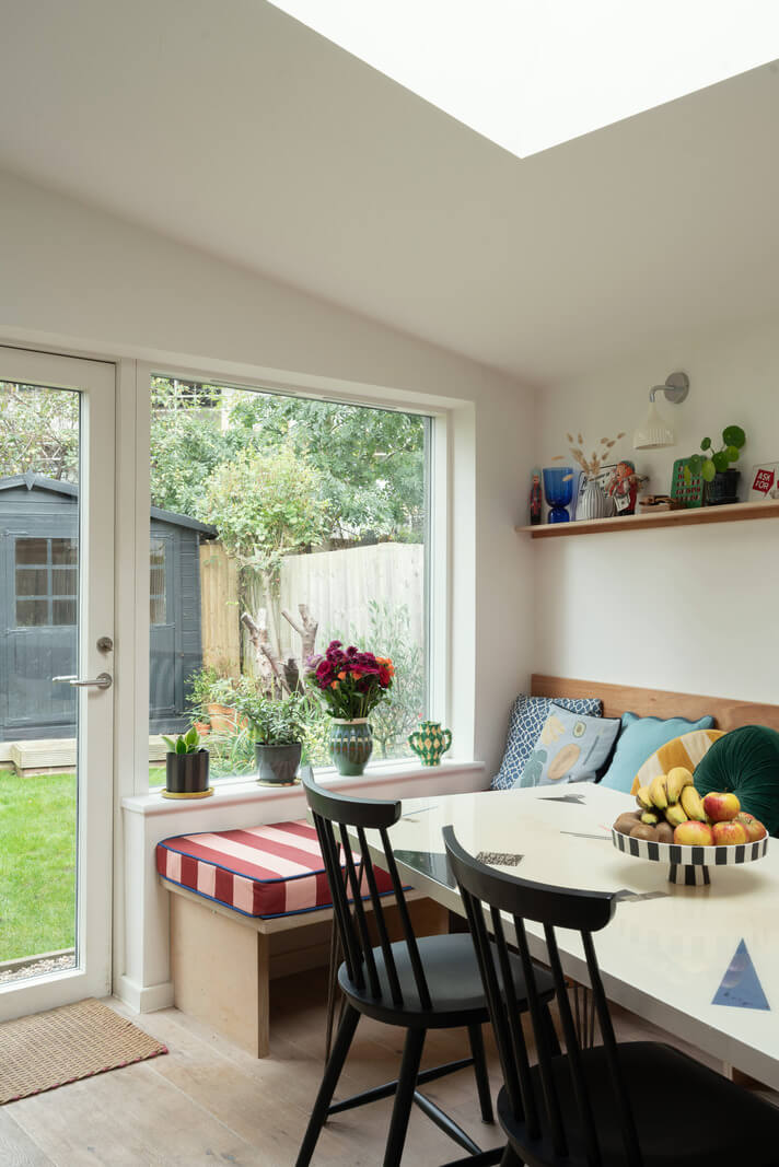 Colorful Rooms and Period Features in a London Terrace House 10 kitchen dining area with built in bench and skylight