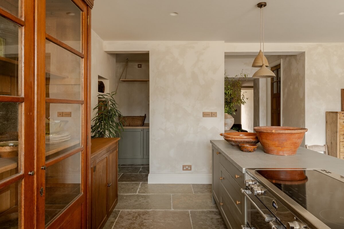 Serene Spaces with Limewash Walls in an English Victorian Home 6 kitchen with island glass fronted wooden cabinets open utility room