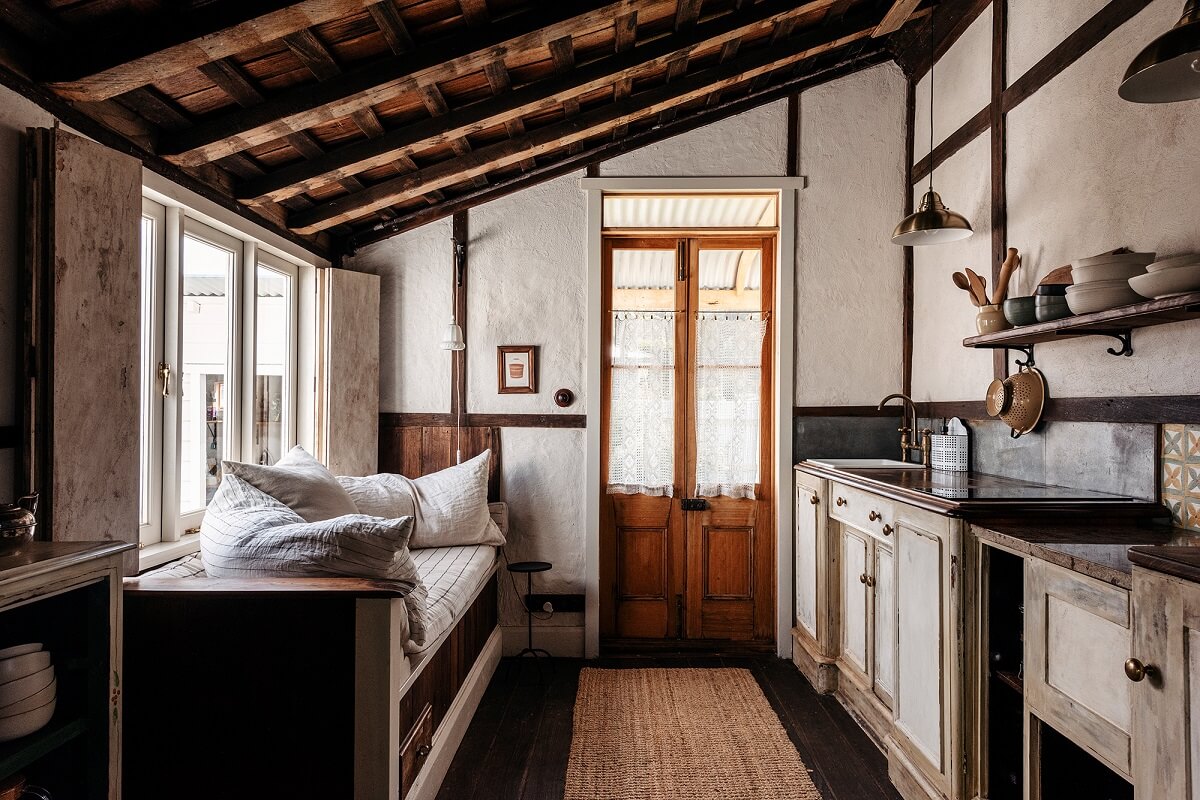 A Cozy Rustic Shipbuilder's Cottage in Northern Tasmania 9 kitchen with slanted wooden ceiling and window seat
