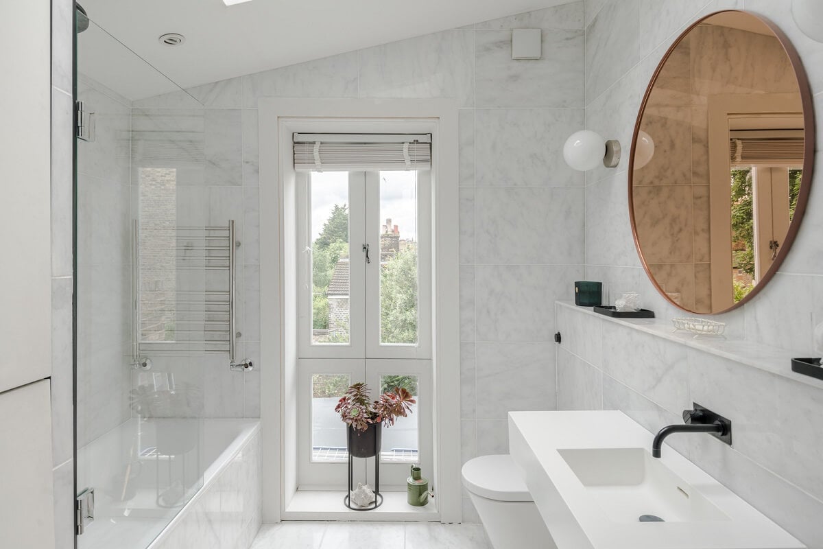 A Bright Extended and Renovated Victorian House in London 17 light bathroom with slanted ceiling and black fittings