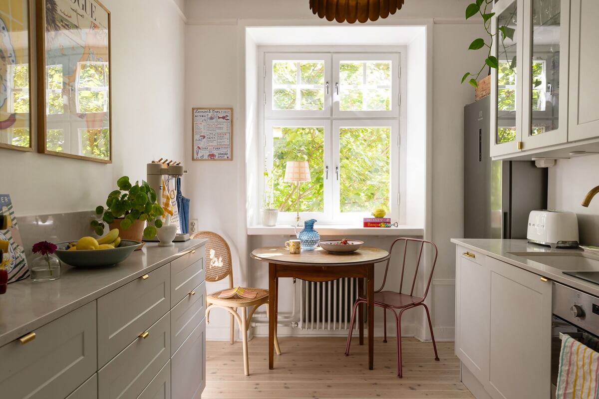 Soft Colors in a Charming Corner Apartment in Stockholm 13 light gray kitchen with round table under window